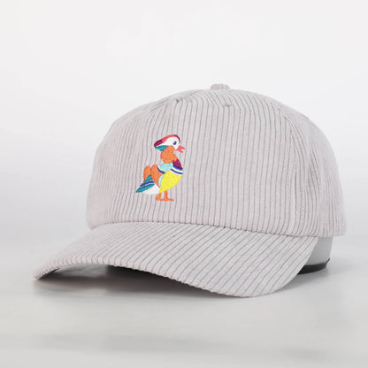 A three-quarter front view of a recycled corduroy hat from Bird Club, featuring an embroidered mandarin duck logo. The hat's light gray corduroy fabric provides a stylish, textured look. The colorful embroidery of the mandarin duck adds a vibrant touch, reflecting the brand's passion for bird watching and ornithology. This hat is part of a sustainable brand collection, emphasizing eco-friendly materials. 