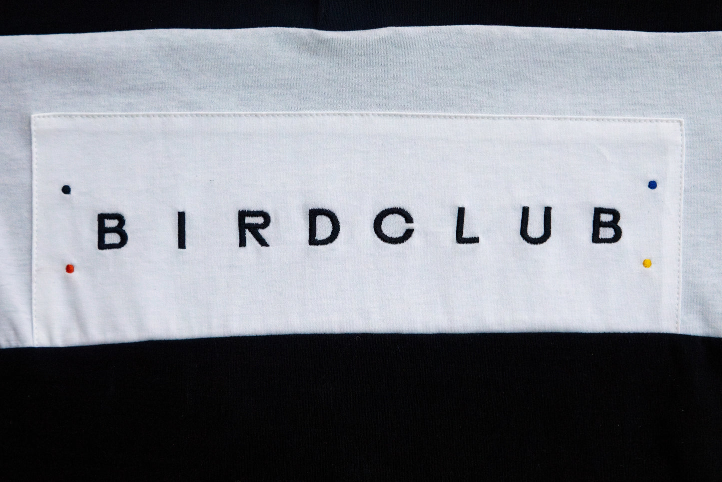 Detail of the embroidered Bird Club wordmark stitched onto the front of the ornithology shirt, emphasizing premium craftsmanship and sustainability. A perfect gift for birders and bird lovers.