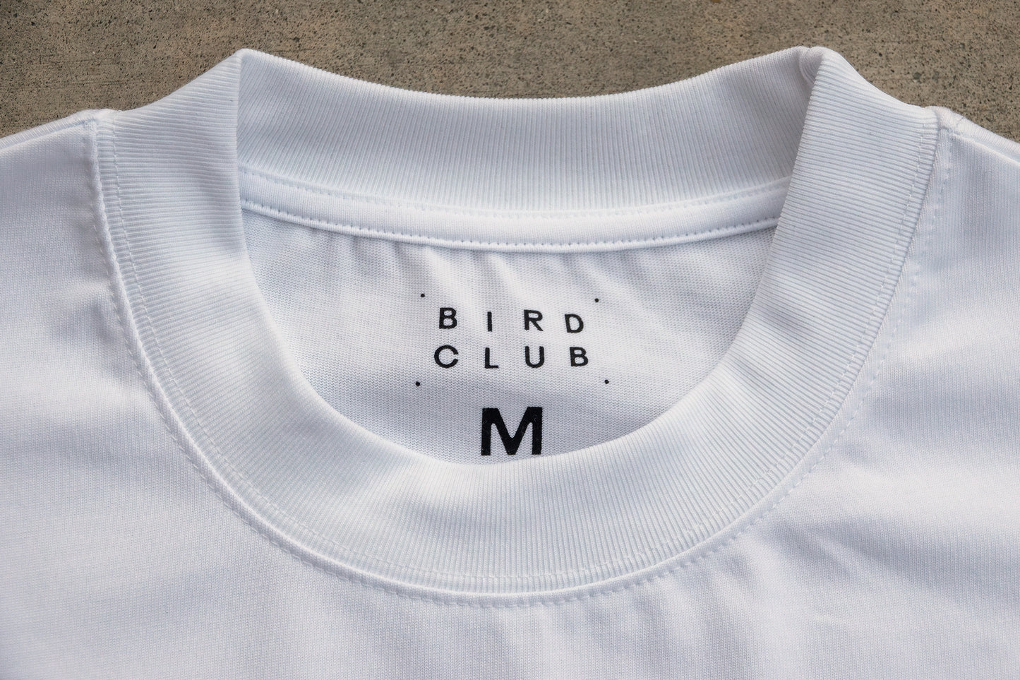 High-quality close-up of the ribbed collar on the organic cotton t-shirt by Bird Club. A premium gift for bird watchers and bird lovers alike.